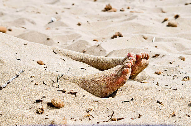 the feet of a corpse that protrude from the sand